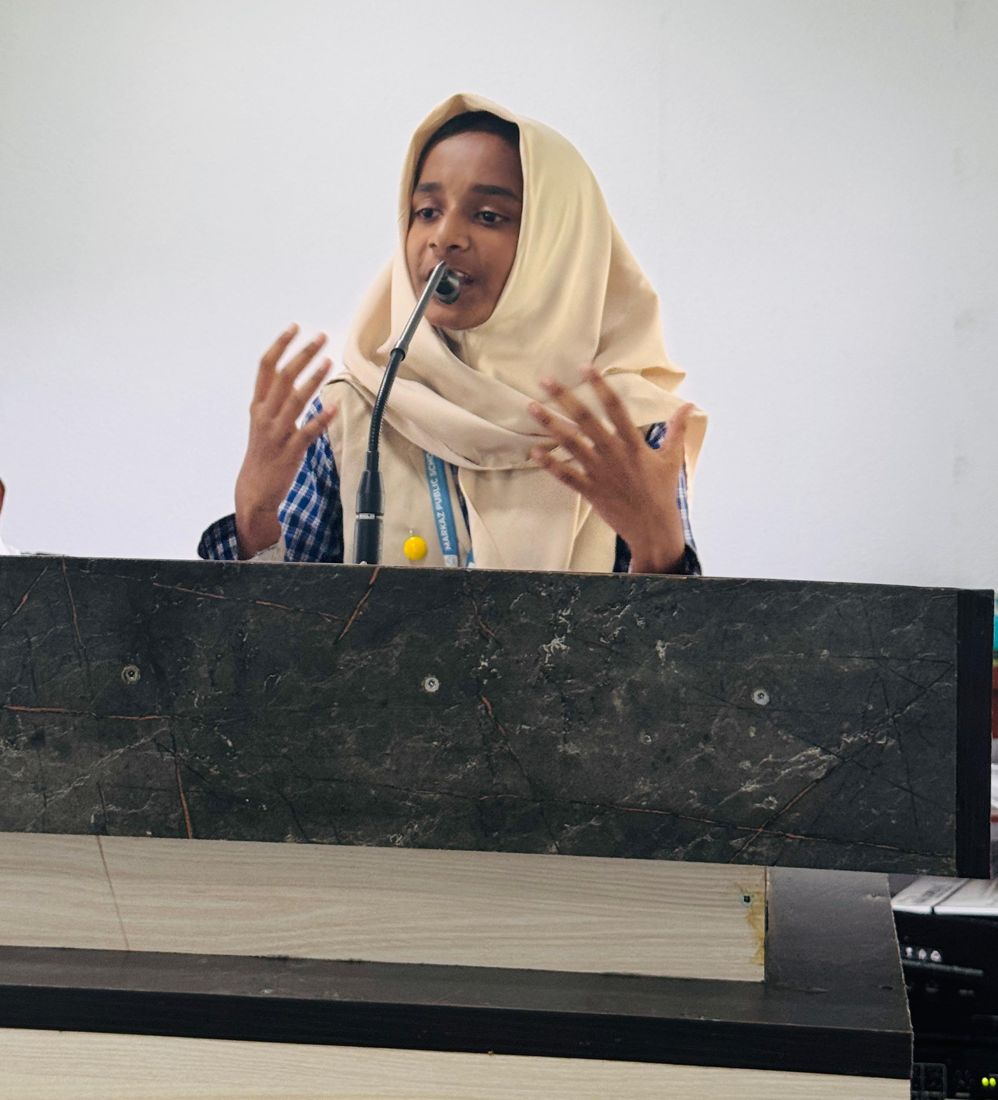 A student speaking at the podium microphone